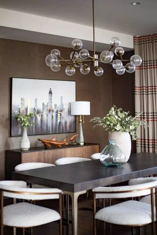 a mid-century modern taupe dining room with a credenza, a dark table and creamy chairs, a lovely chandelier