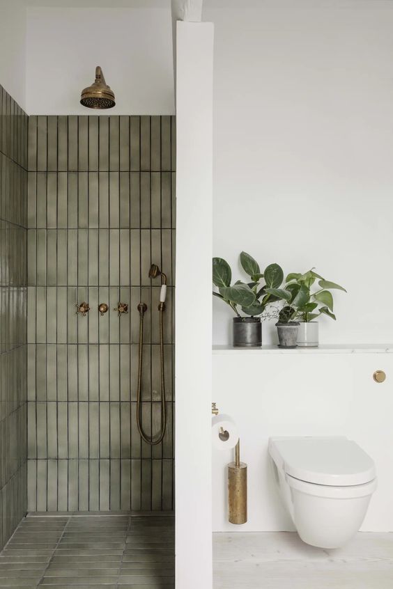 a modern bathroom with a shower space with green stacked matte tiles and all white everything around is amazing