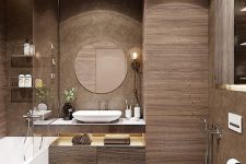a modern brown bathroom clad with wood-like tiles, a floating vanitu and a storage unit, white appliances