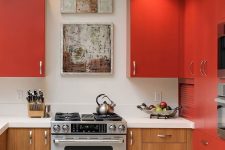 a modern matte red kitchen with lower stained cabinets, a white countertop and backsplash plus built-in lights
