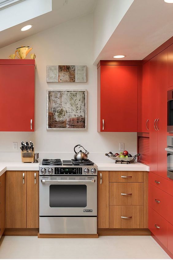 a modern matte red kitchen with lower stained cabinets, a white countertop and backsplash plus built-in lights