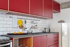 a modern red kitchen with a white subway tile backsplash, grey stone countertops, open shelves is a catchy space