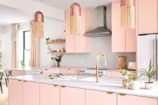 a peachy pink kitchen with plain cabinets, a large kitchen island, a white backsplash and coutnertops, pendant lamps with fringe