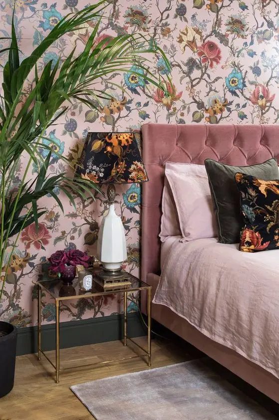 a pink floral wallpaper continues the theme of the bedroom and adds whimsiness to the space