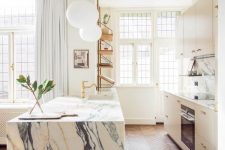 a pretty kitchen with tan cabinets, a white marble backsplash and a kitchen island, a herringbone floor and open shelves
