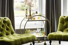 a refined nook with elegant chartreuse tufted chairs, a chic bar cart and grey curtains is a cool space