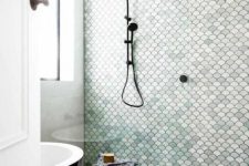 a simple shower is made cooler with aqua-colored, white and blush fishscale tiles that mismatch in color but match in shape