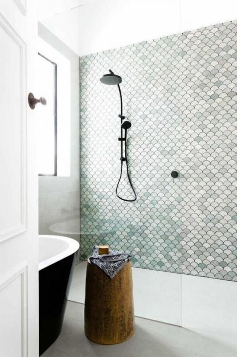 A simple shower is made cooler with aqua colored, white and blush fishscale tiles that mismatch in color but match in shape