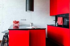 a statement red kitchen with black countertops and a backsplash, a black hood and stools looks very edgy
