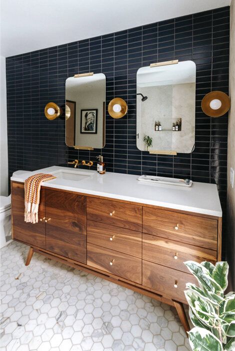 a stylish modern farmhouse bathroom with a black stacked tiles on the wall and marble hex ones on the floor, a stained vanity