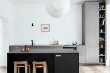 a stylish modern kitchen with white walls and a neutral herringbone floor, grey cabinetry, a black kitchen island
