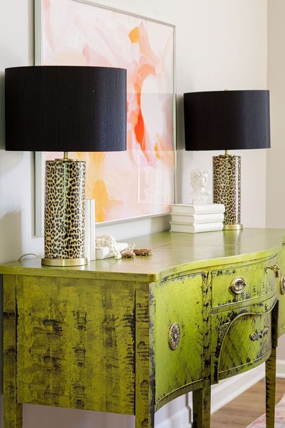 a super glam chartreuse console table with a brushed finish and leopard table lamps is wow