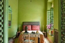 a unique chartreuse Marocco-inspired bedroom with a grey bed and colorful bedding, a metal pendant lamp and a desk with a chair