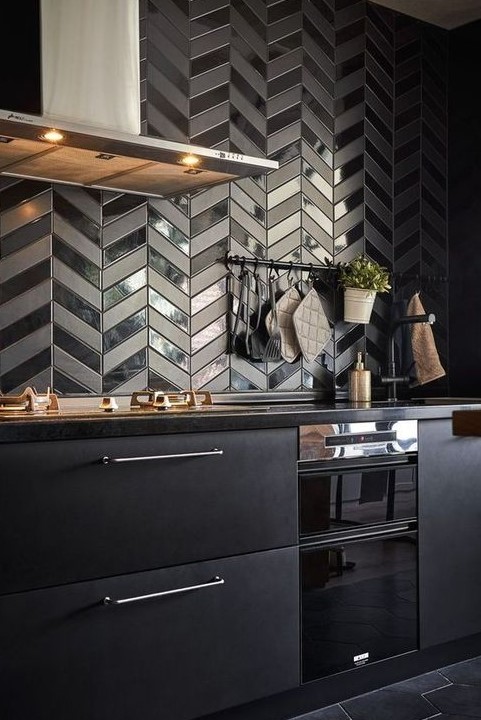 a very eye-catchy herringbone tile backsplash in matte and shiny finishes is very bold