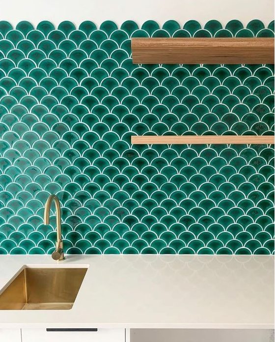 a white kitchen with a bold emerald scallop tile backsplash, open stained shelves and gold touches is fantastic