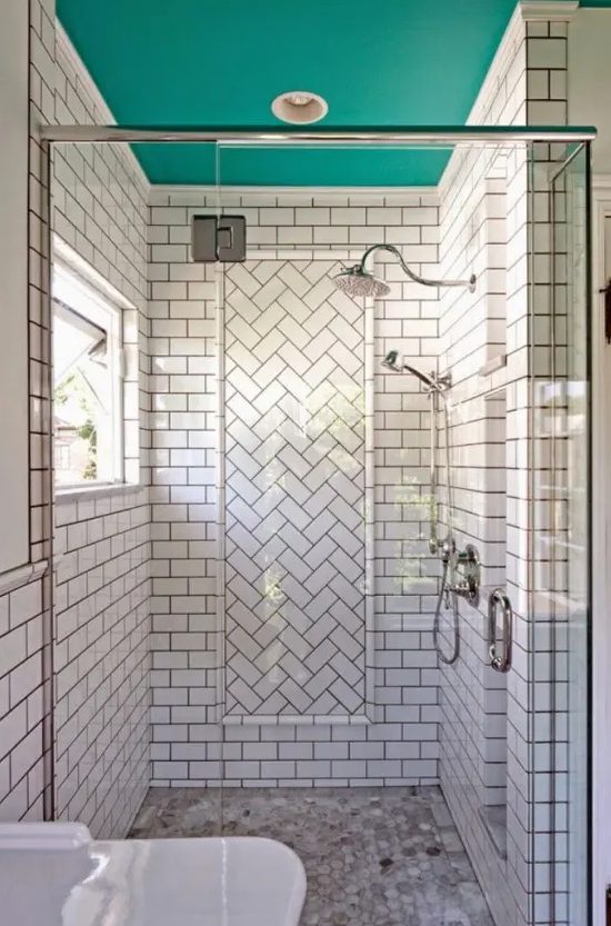 a white subway tile shower space with a herringbone accent and a turquoise ceiling is a bold and cool idea