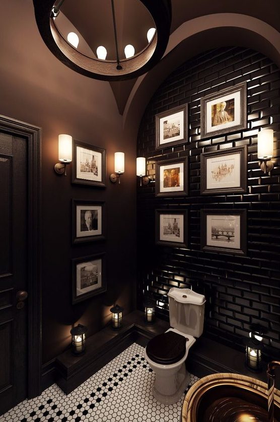 an art deco powder room with chocolate brown walls and a tiled wall, a gallery wall and touches of brass