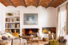 an earthy living room with a birck ceiling, a fireplace, neutral seating furniture, basket and built-in bookshelves