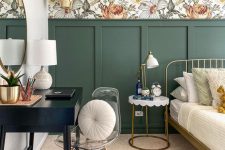 an eye-catchy bedroom with bold floral wallpaper, green paneling, a metal bed with neutral bedding, a nightstand, a black vanity and a clear chair