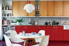 an eye-catchy modern kitchen with light-stained and red cabinets, white tiles on the backsplash and white chairs