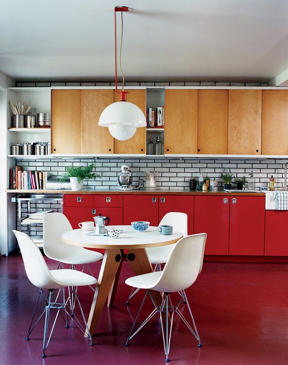 an eye-catchy modern kitchen with light-stained and red cabinets, white tiles on the backsplash and white chairs