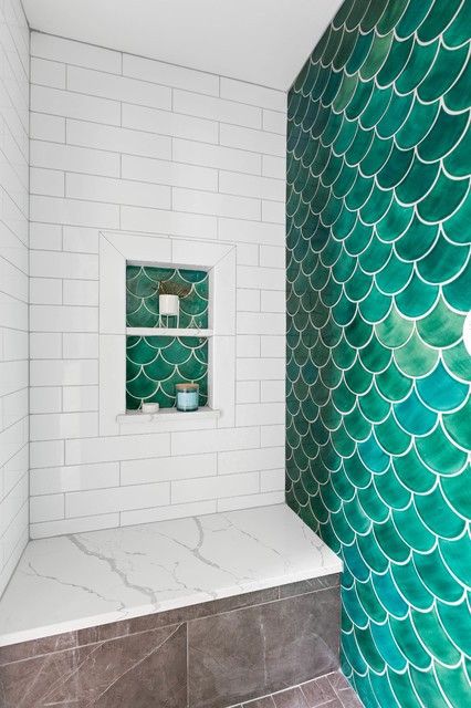 An eye catchy shower space done with marble subway and green fishscale tiles, a niche shelf is a cool and bold idea