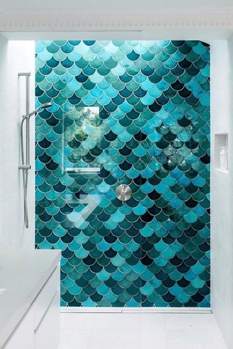 Sea inspired misatching in color but matching in size fishscale tiles accentuate the shower space and make it stand out in the neutral space
