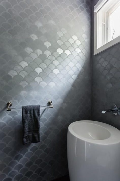 Ultra modern bathroom with gray metallic fishscale tiles and a white egg shaped free standing sink