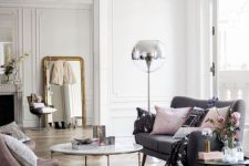 a French chic meets Scandinavian living room with chevron flooring, a grey sofa, a pink chair, a floor lamp and a coffee table