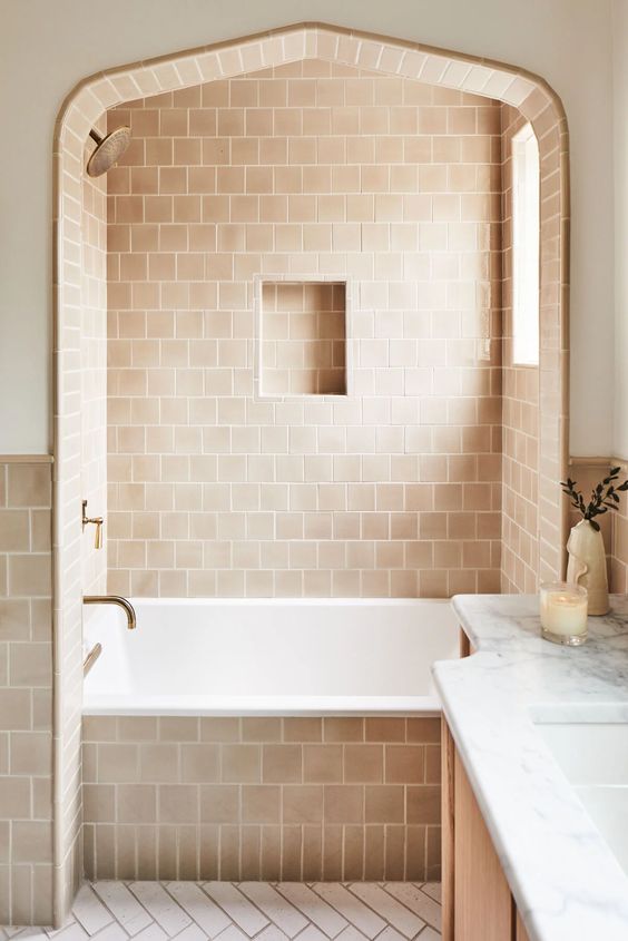 a beautiful bathroom done with terracotta and white tile, a bathing space with a window, a vanity and a mirror