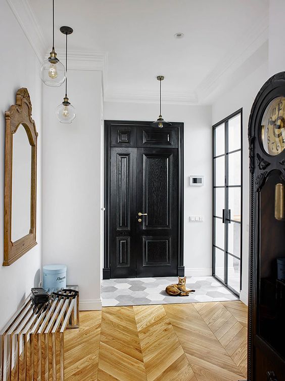 a bold entryway with a tile and chevron floor, a bold bench, a mirror and some pendant lamps