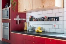 a bold mid-century modern kitchen with bright red lower cabinets and neutral upper ones plus a white tile backsplash