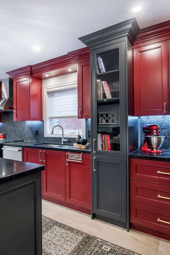 a bright cherry red kitchen with shaker cabinets, a grey glass one, black countertops and a blue tile backsplash