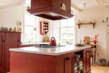 a burgundy kitchen with shaker cabinets, terrazzo countertops and a large hood plus beautiful and chic decor
