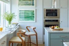 a coastal light blue kitchen with plain cabinets, a kitchen island, a windowsill breakfast bar with storage and cool stools