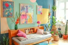 a colorful dopamine living room with a blue accent wall with geo prints, a daybed with a bookshelf, potted plants and bright artwork