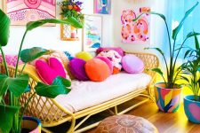 a colorful dopamine living room with a rattan sofa and colorful pillows, a colorful gallery wall, colorful pots and a brown pouf