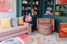 a colorful living room with dark green arched bookcases, a pink sofa with pastel pillows, a bright chair and a rug
