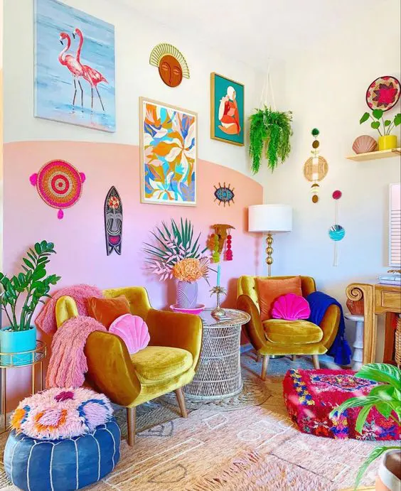 a colrful dopamine decor living room with a pink accent wall, marigold chairs, colorful pillows and poufs and a bold gallery wall