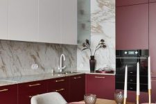 a contemporary chic kitchen with white upper and burgundy lower cabinets, marble countertops and a backsplash