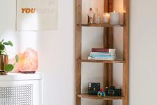 a cool and simple stained corner shelving unit with books, cameras and candles is a lovely idea for a modern space