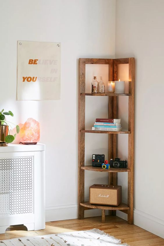 a cool and simple stained corner shelving unit with books, cameras and candles is a lovely idea for a modern space