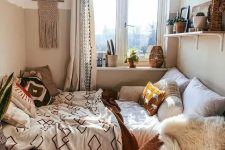 a cozy boho bedroom with a bed, a shelf with decor, a chair with faux fur and a pouf plus a lot of boho decor