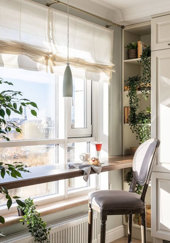 A cozy breakfast bar with built in shelves, a vintage chair, a pendant lamp and a lovely view of the city