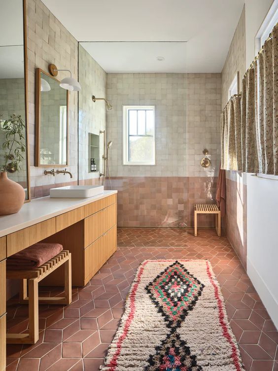 a creative boho bathroom with terracotta and Zellige tile, a large vanity, a shower space and a large boho rug