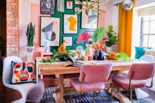 a dopamine decor dining room with a green accent wall and a bold gallery wall, a table, pink chairs, colorful pillows and greenery