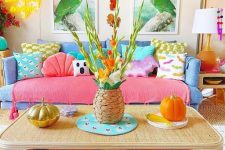 a dopamine decor living room with a blue sofa and colorful pillows, a cane coffee table, bold decor and artwork