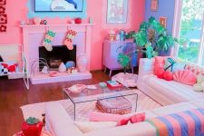 a dopamine decor living room with a bold pink and periwinkle accent wall, a fireplace, a sectional, colorful pillows and blankets and bold decor