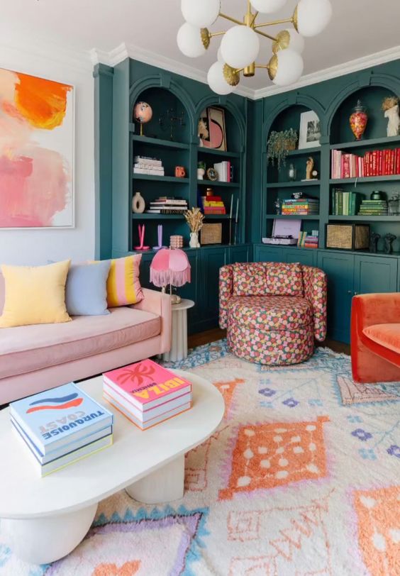 a dopamine decor living room with dark green bookcases, a pink sofa with pastel pillows, a printed rug and a bold chair