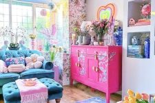 a dopamine decor living room with floral wallpaper, a navy sofa and ottoman, pastel pillows, a hot pink credenza, bold decor and blooms